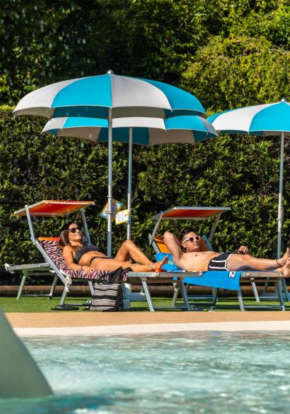 People relax on sun loungers by the pool.