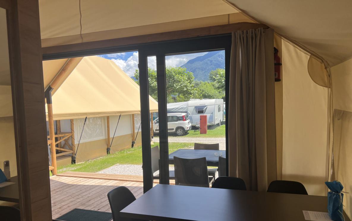 Inside a glamping tent with view of campsite and mountains.