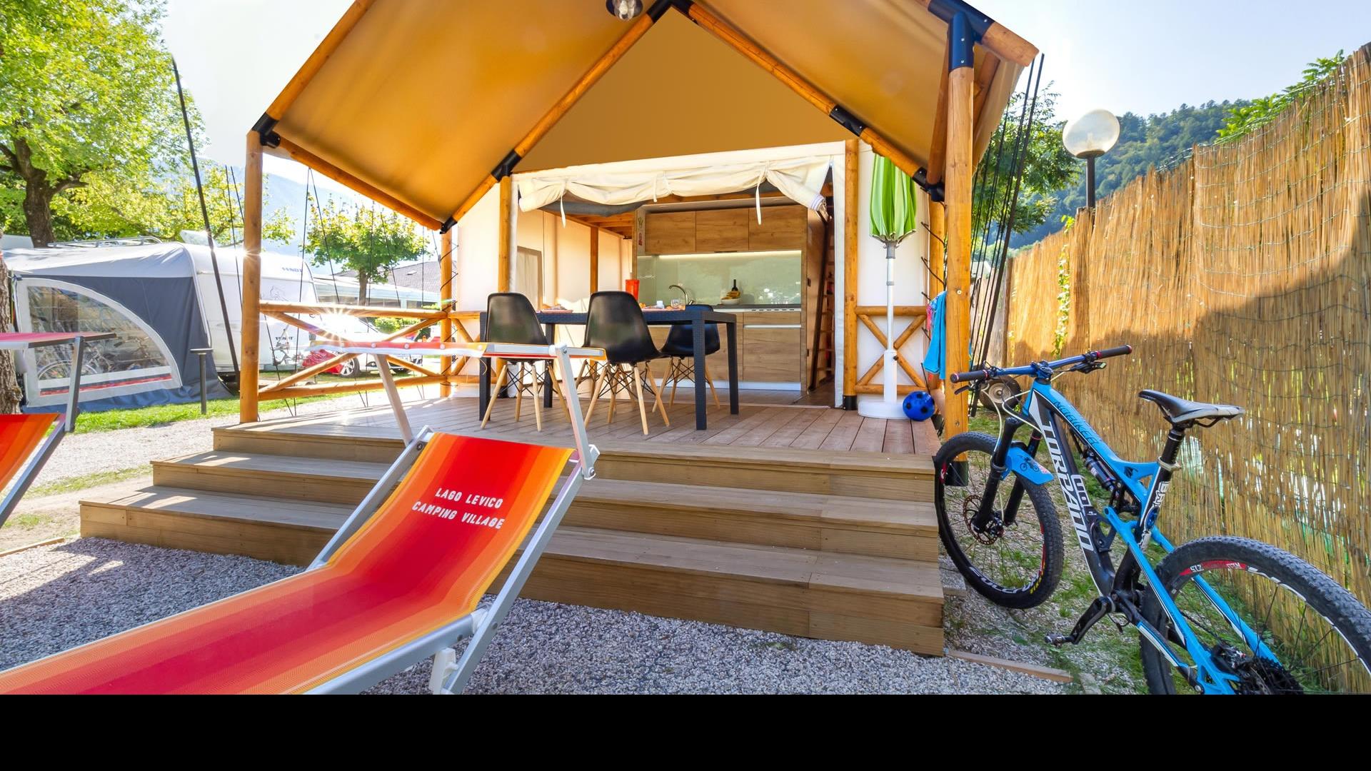 Tenda glamping con veranda, bici e lettini al Lago Levico Camping Village.